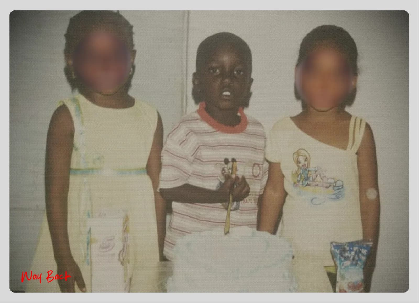 A childhood photograph of three children standing together, faces blurred